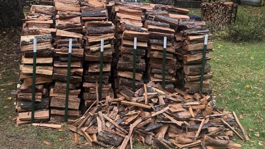 Six full cords of oak stacked neatly between steel posts